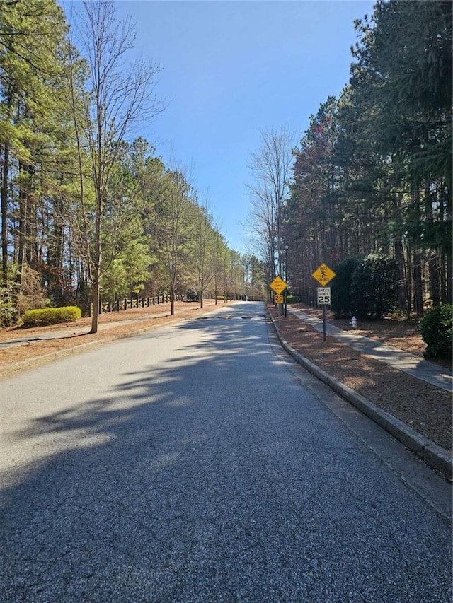 view of road featuring sidewalks, traffic signs, and curbs