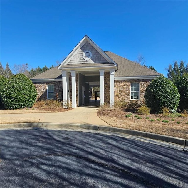 exterior space featuring stone siding and concrete driveway