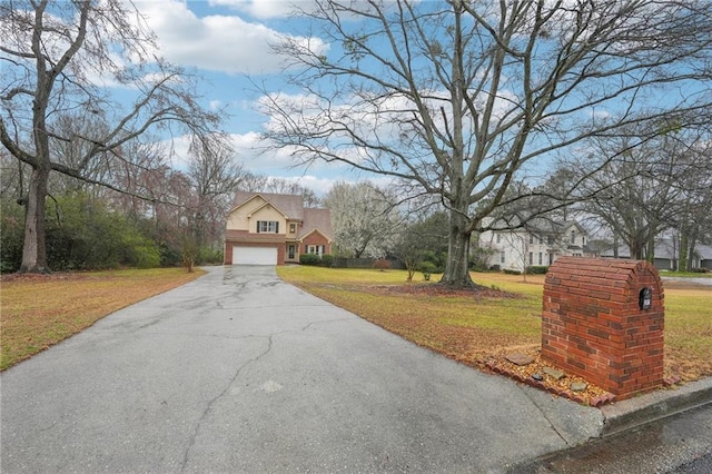 view of front of home featuring a front yard, an attached garage, and driveway