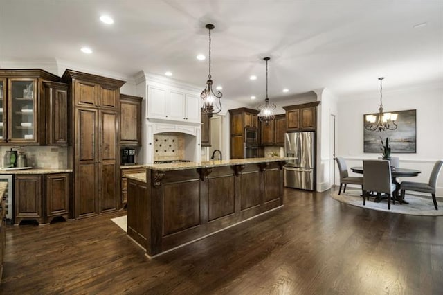 kitchen featuring dark wood-style floors, appliances with stainless steel finishes, a kitchen bar, and dark brown cabinetry