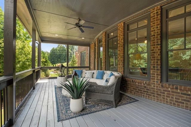 wooden terrace featuring a ceiling fan and an outdoor living space