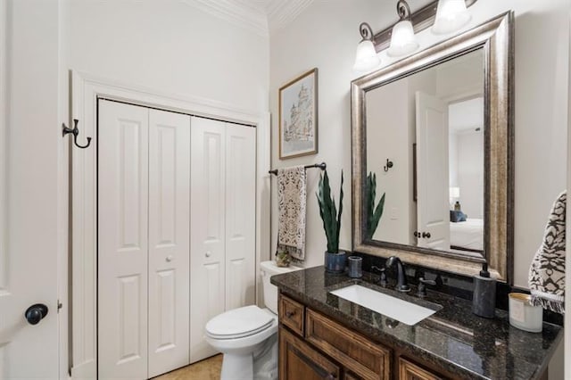 bathroom with ornamental molding, a closet, vanity, and toilet