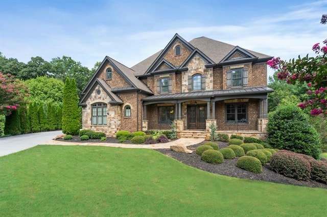 craftsman-style house featuring metal roof, a front lawn, a standing seam roof, and a porch