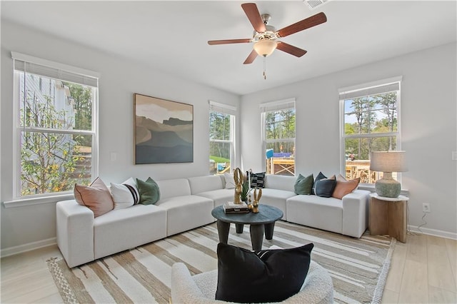 living room featuring plenty of natural light, baseboards, and wood finished floors