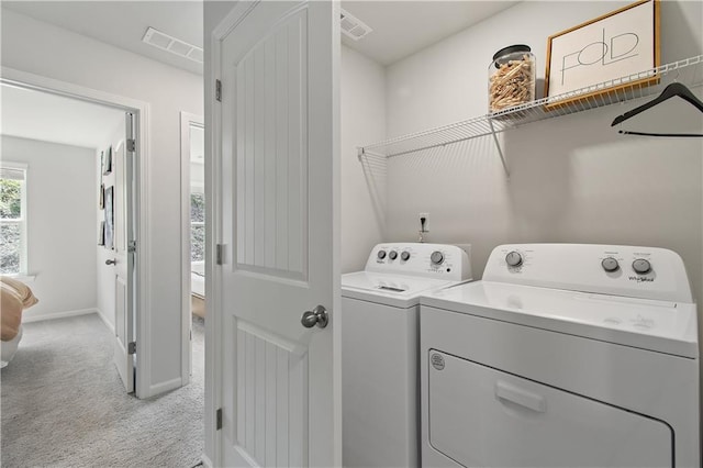 washroom featuring light colored carpet, washer and dryer, visible vents, and baseboards