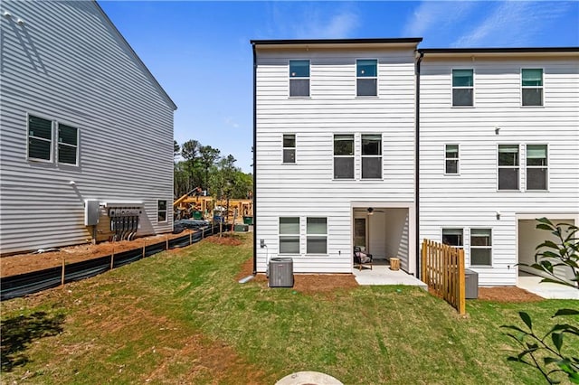 back of property featuring cooling unit, fence, a lawn, and a patio