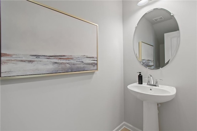 bathroom featuring visible vents, a sink, and baseboards