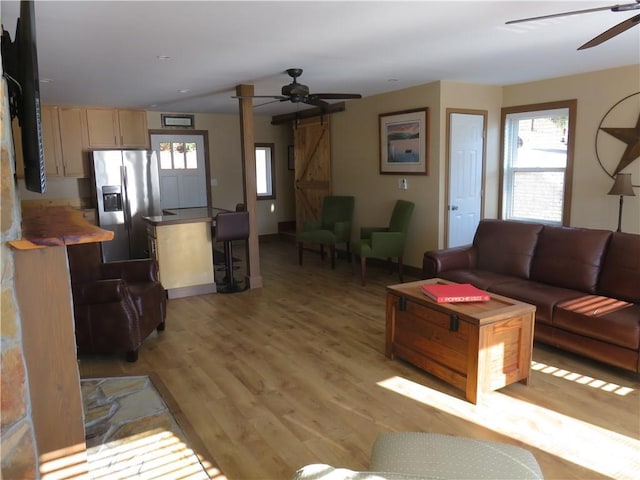 living area featuring light wood-style flooring and ceiling fan