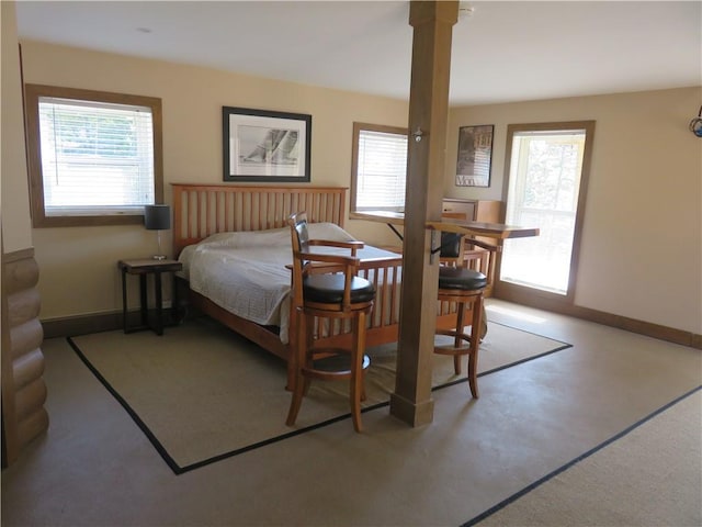 bedroom featuring baseboards and multiple windows