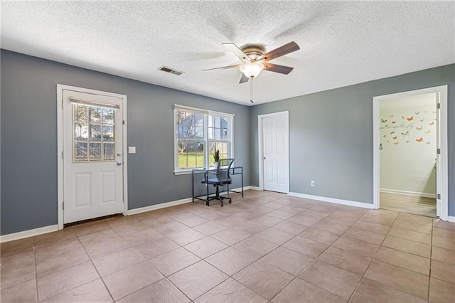 unfurnished office featuring ceiling fan, plenty of natural light, and light tile patterned floors