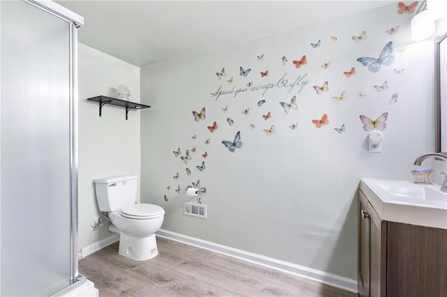 bathroom with vanity, hardwood / wood-style flooring, a shower with shower door, and toilet