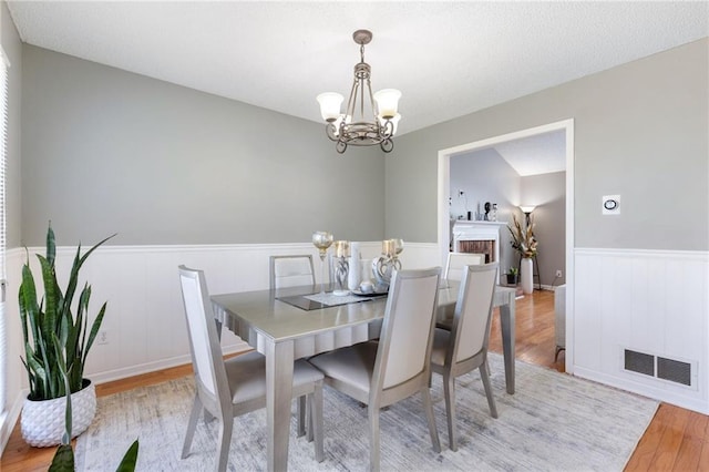 dining space with an inviting chandelier and light hardwood / wood-style floors