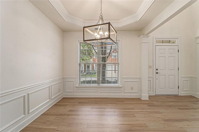 401 Wellwood Way, Roswell, GA 30075 - unfurnished dining area with a chandelier, a tray ceiling, a decorative wall, crown molding, and light wood-style flooring
