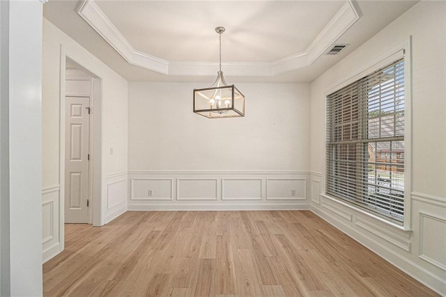 401 Wellwood Way, Roswell, GA 30075 - unfurnished dining area featuring a chandelier, a raised ceiling, light wood-type flooring, ornamental molding, and a decorative wall