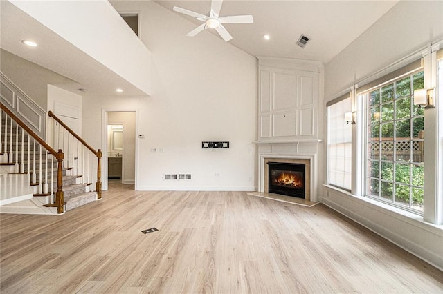 401 Wellwood Way, Roswell, GA 30075 - unfurnished living room featuring light wood finished floors, healthy amount of natural light, ceiling fan, stairs, and high vaulted ceiling