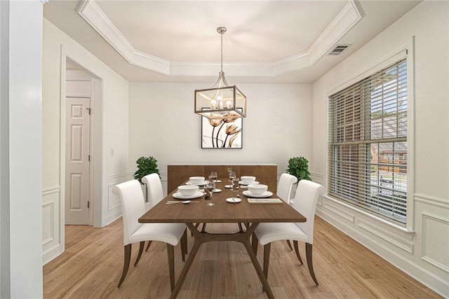 401 Wellwood Way, Roswell, GA 30075 - dining space with light wood finished floors, crown molding, a tray ceiling, a chandelier, and a wainscoted wall