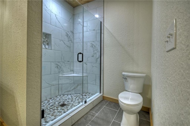 bathroom featuring tile patterned floors, toilet, and walk in shower