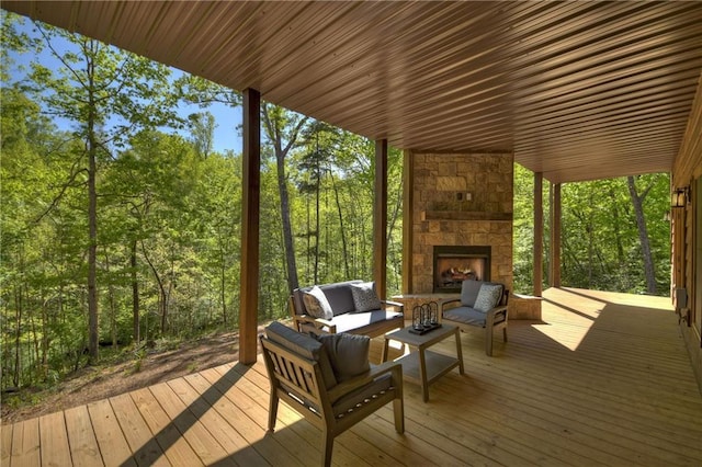 wooden deck with an outdoor living space with a fireplace