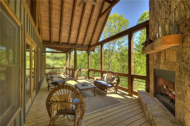 sunroom / solarium with vaulted ceiling with beams, wood ceiling, and a fireplace