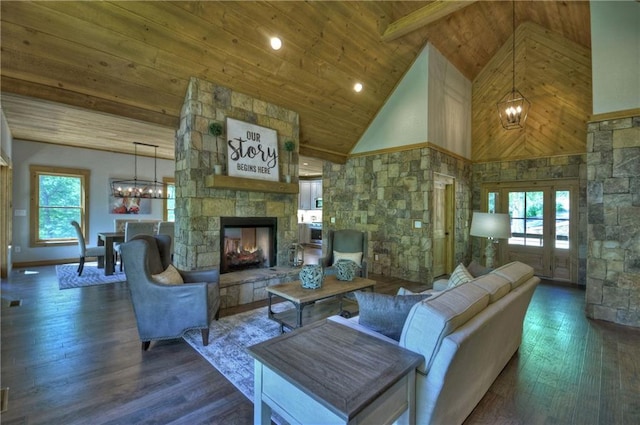 living room featuring a notable chandelier, dark wood-type flooring, wooden ceiling, and a fireplace