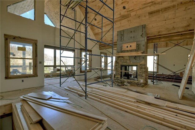 living room featuring a stone fireplace, a healthy amount of sunlight, and hardwood / wood-style floors