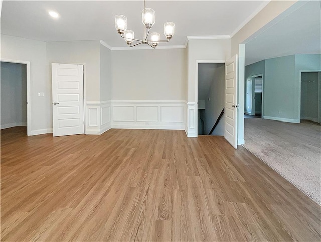 unfurnished dining area featuring light hardwood / wood-style floors, ornamental molding, and a chandelier