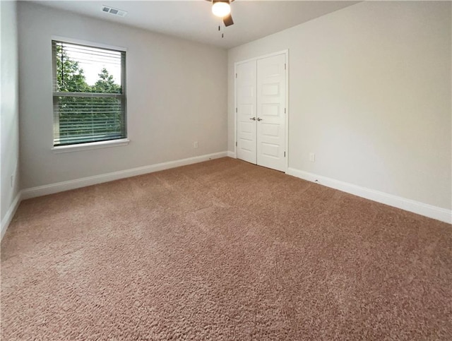 unfurnished bedroom with ceiling fan, carpet floors, and a closet