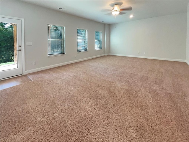 carpeted empty room featuring ceiling fan and a healthy amount of sunlight