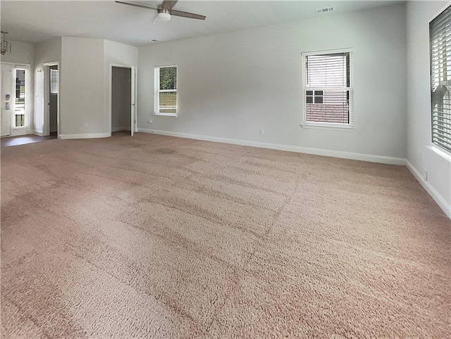 unfurnished room featuring plenty of natural light, carpet floors, and ceiling fan with notable chandelier