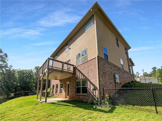 rear view of property with a lawn, ceiling fan, and a patio area