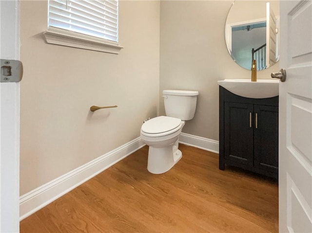 bathroom featuring wood-type flooring, vanity, and toilet