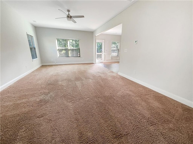 unfurnished living room featuring carpet and ceiling fan