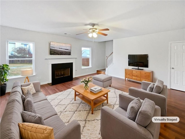 living room with a fireplace with flush hearth, wood finished floors, and baseboards