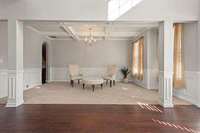 living area featuring coffered ceiling, ornate columns, beam ceiling, and hardwood / wood-style flooring