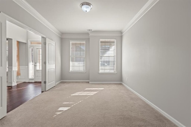 carpeted empty room with plenty of natural light and ornamental molding