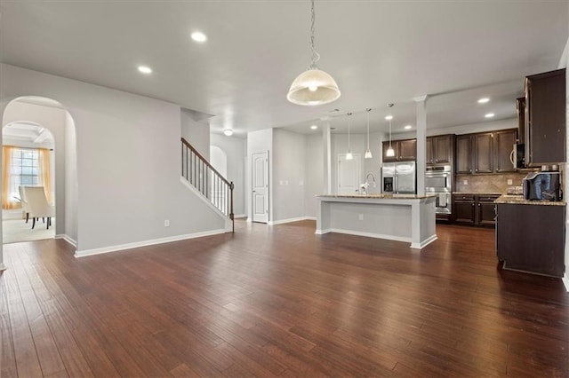 unfurnished living room featuring dark hardwood / wood-style flooring and sink