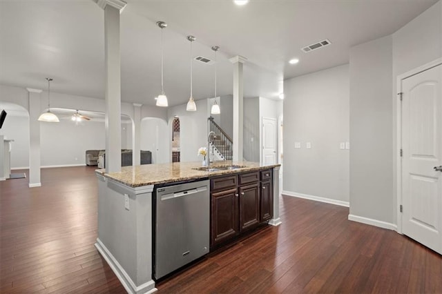 kitchen with stainless steel dishwasher, light stone countertops, sink, and hanging light fixtures