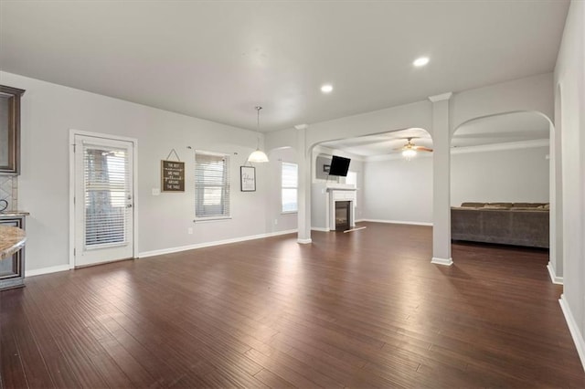 unfurnished living room with dark hardwood / wood-style floors and ceiling fan