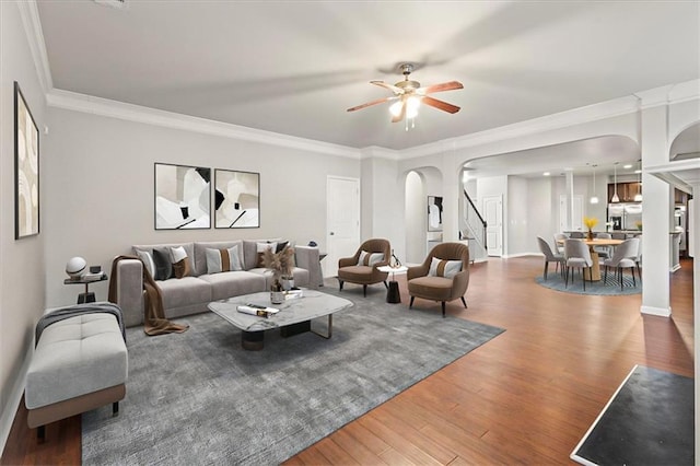 living room with crown molding, dark hardwood / wood-style floors, and ceiling fan