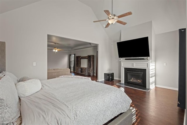 bedroom with ceiling fan, high vaulted ceiling, and dark hardwood / wood-style flooring