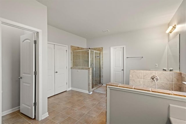 bathroom with an enclosed shower and tile patterned flooring