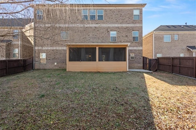 rear view of house with a yard and a sunroom