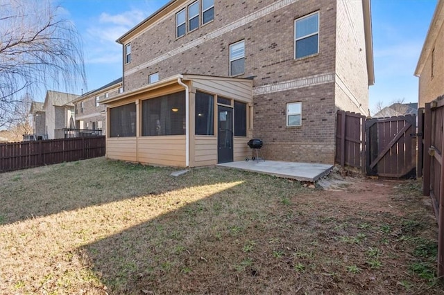 rear view of house with a yard, a sunroom, and a patio