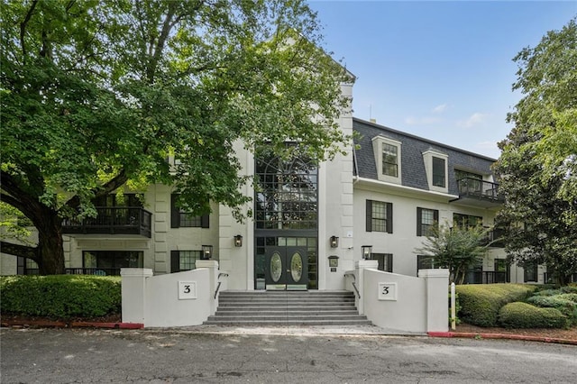 view of front of home with a balcony and french doors