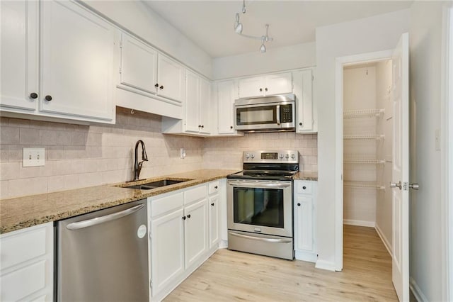 kitchen with light wood-type flooring, white cabinetry, sink, and stainless steel appliances