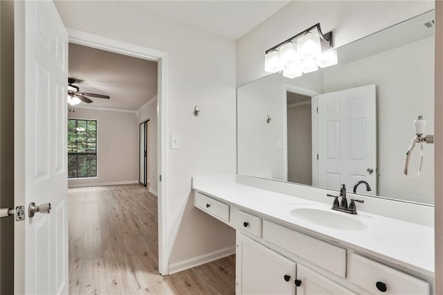 bathroom featuring hardwood / wood-style floors, ceiling fan, vanity, and crown molding