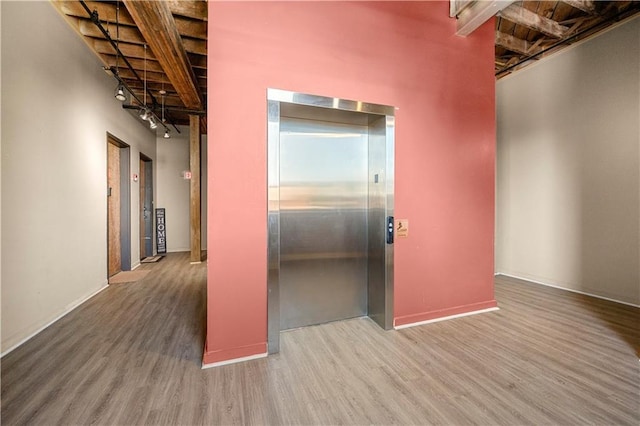 hallway featuring hardwood / wood-style flooring, elevator, and a high ceiling