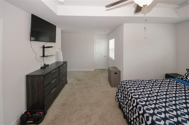 bedroom featuring light colored carpet, a ceiling fan, and baseboards