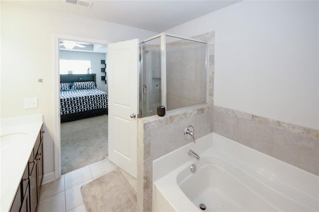 full bathroom featuring tile patterned floors, a stall shower, vanity, a bath, and ensuite bath