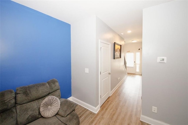 sitting room featuring baseboards and light wood-style floors